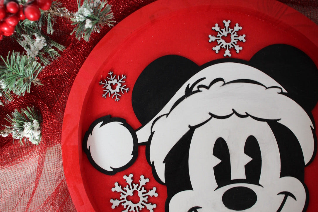 Red plate with a black and white design of a character wearing a Santa hat, surrounded by Christmas decorations.
